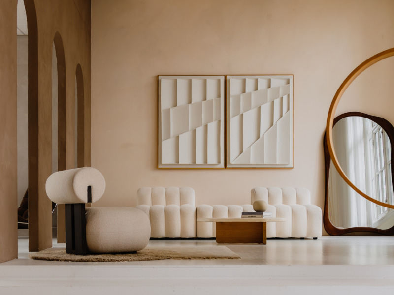 Woonkamer met boekle bank en abstracte wandkunst — interieurfotografie Amsterdam