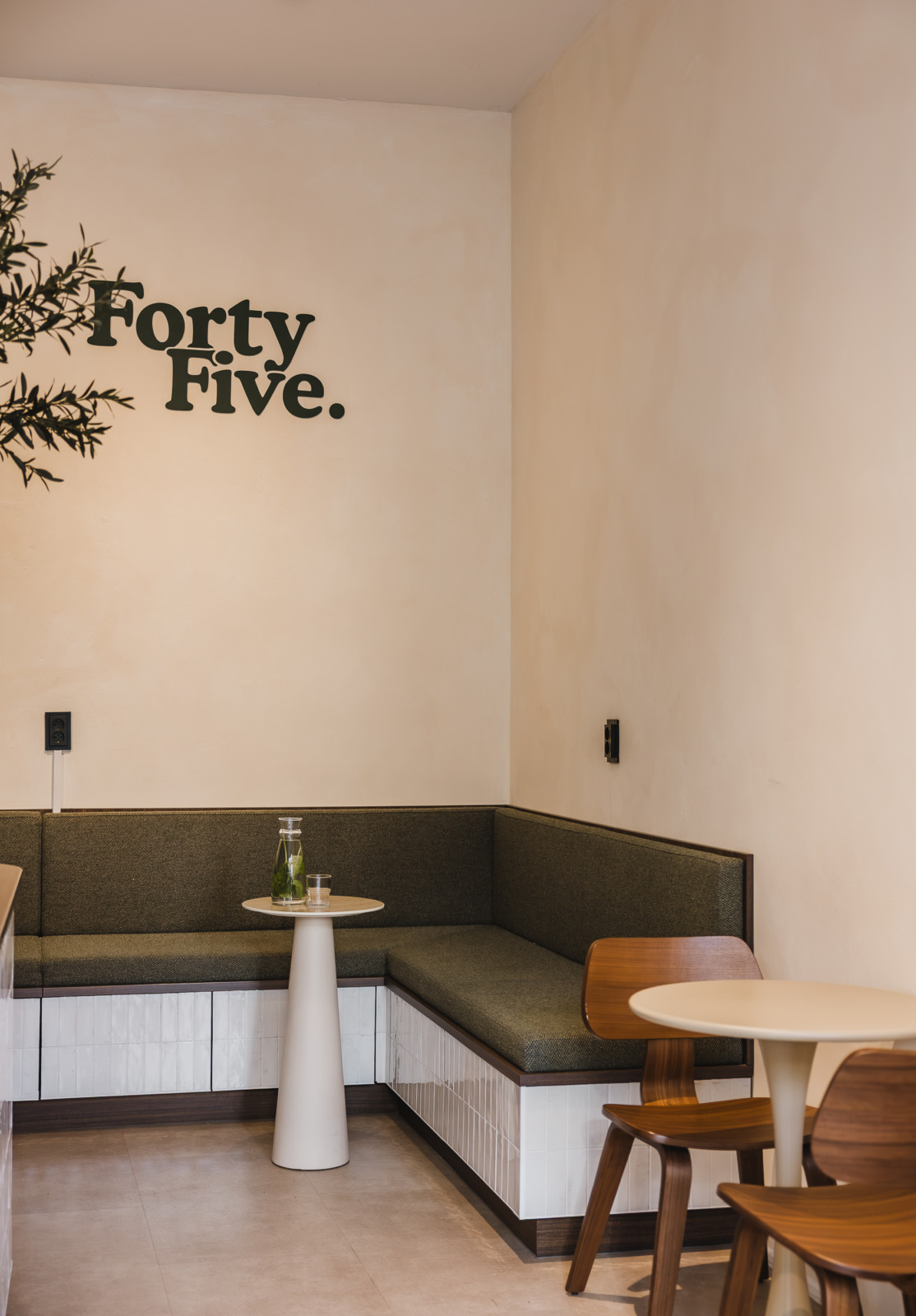 Groene bank met het logo van Forty Five op de muur, koffiebar in Utrecht